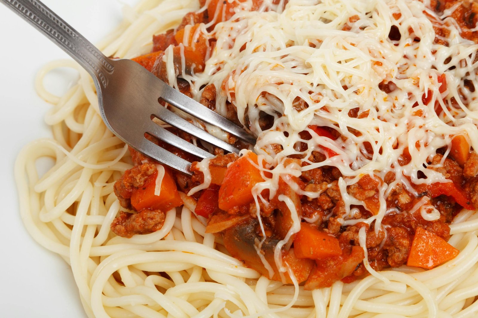 Close-up of delicious spaghetti topped with bolognese sauce and cheese.